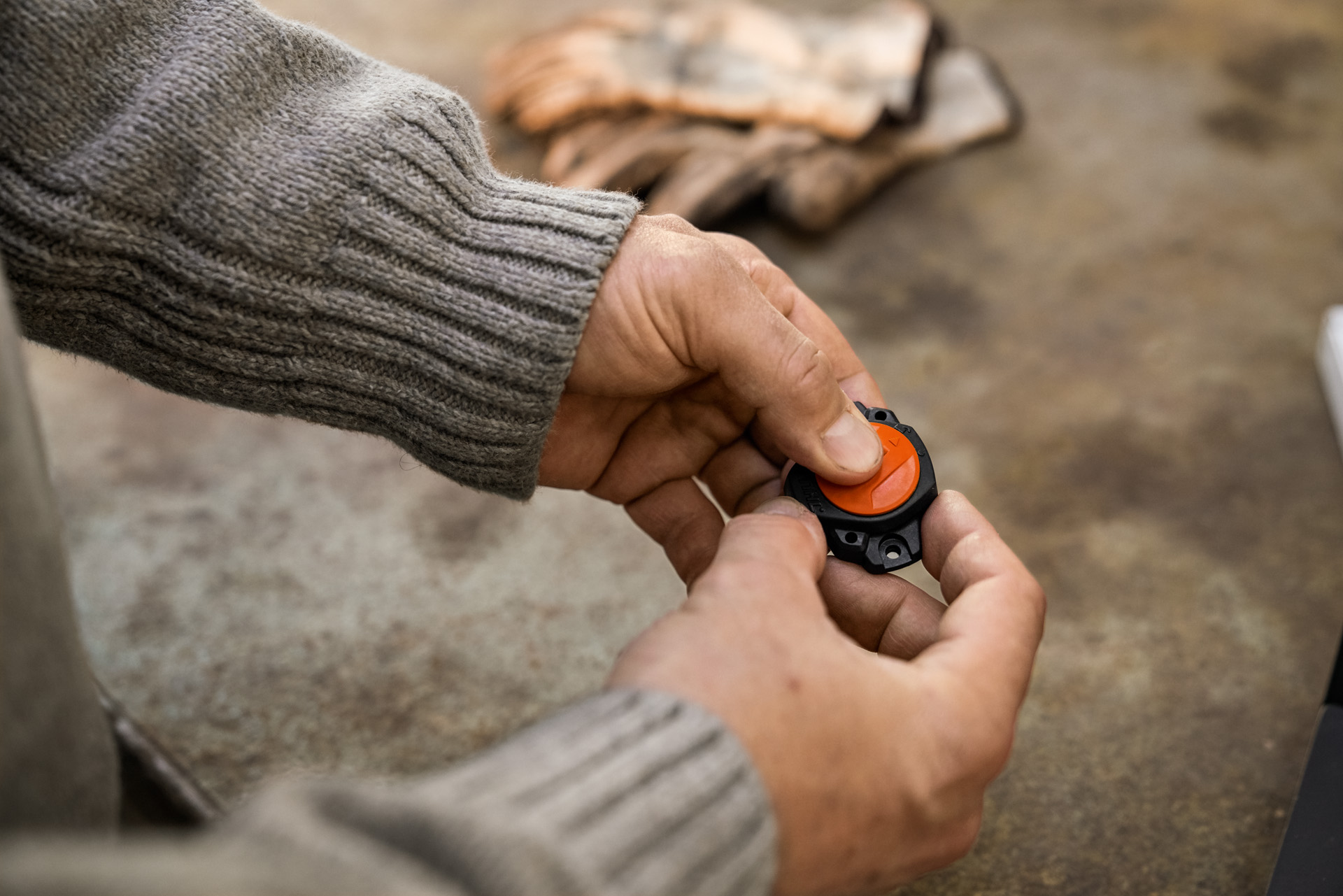 Close-up: Person holding a STIHL Smart Connector in their hand